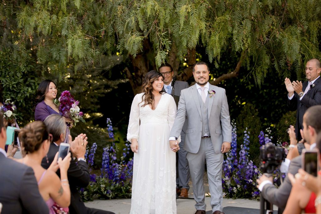 Bride and groom in romantic outdoor wedding ceremony with purple flowers at The Fig House Los Angeles