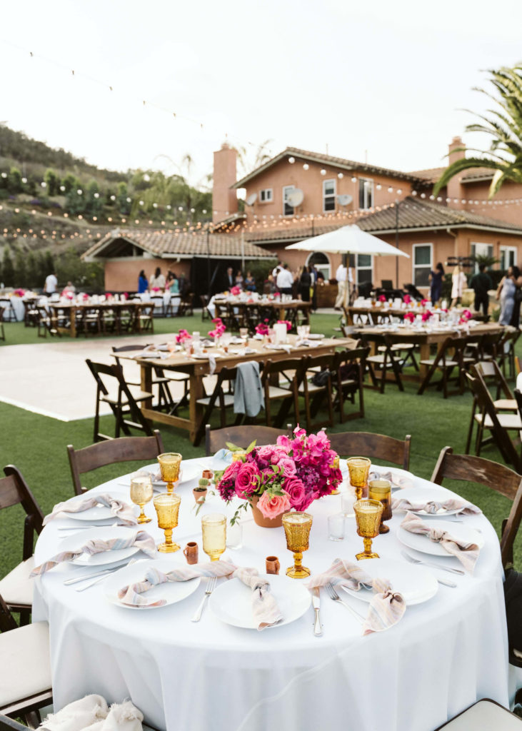 Fiesta inspired outdoor wedding centerpiece with pink flowers and gold goblets