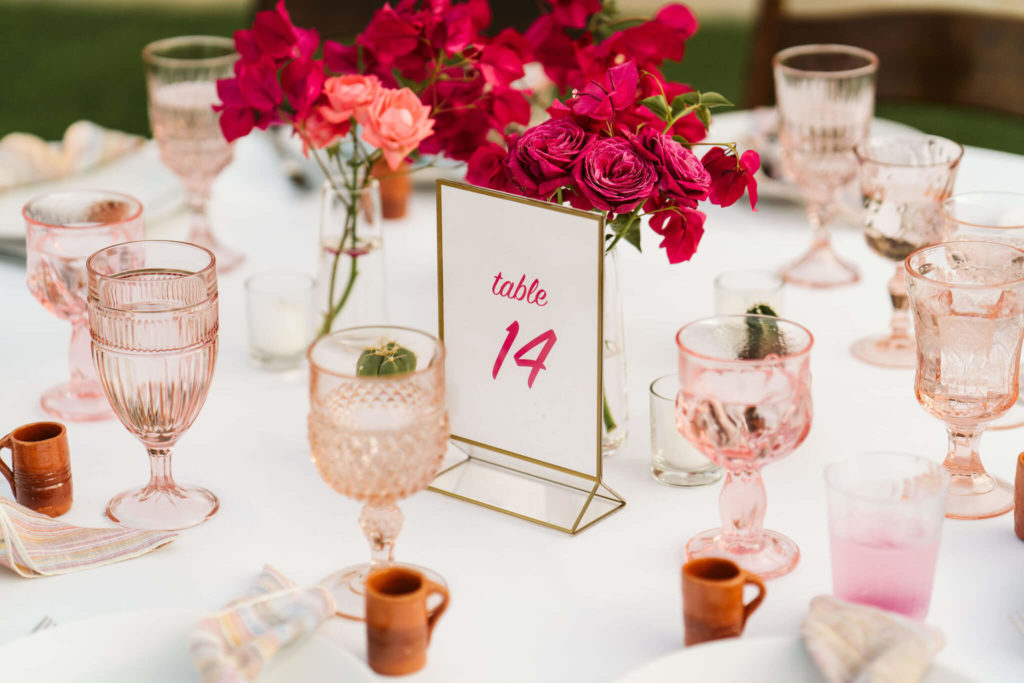 Fiesta inspired wedding centerpiece with pink flowers and pink goblets