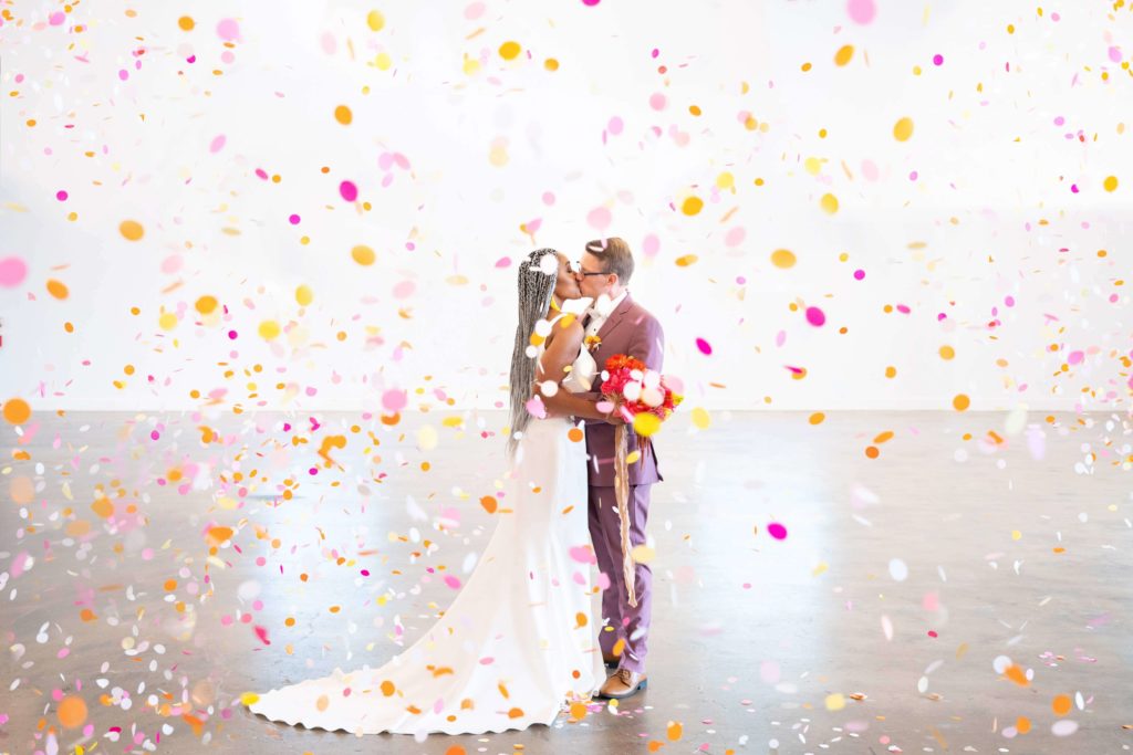 Couple kissing with confetti at LA contemporary color blocked wedding