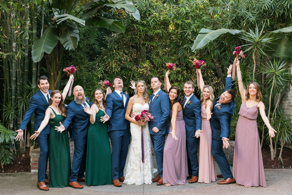 Bride and groom with wedding party wearing jewel tones