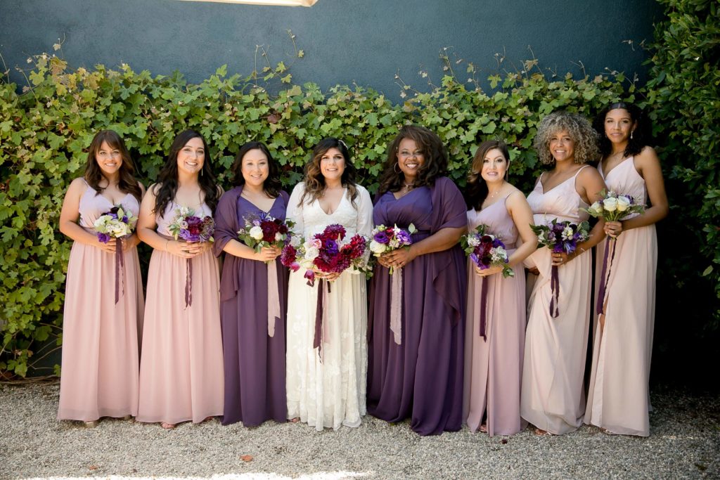 Bridal party wearing purple and mauve dresses with purple bouquets at The Fig House Los Angeles