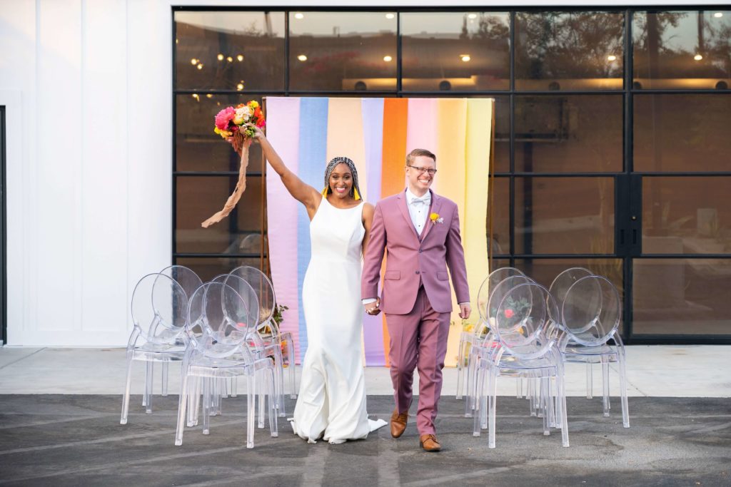 Bride and groom at industrial outdoor ceremony with colorful backdrop in LA