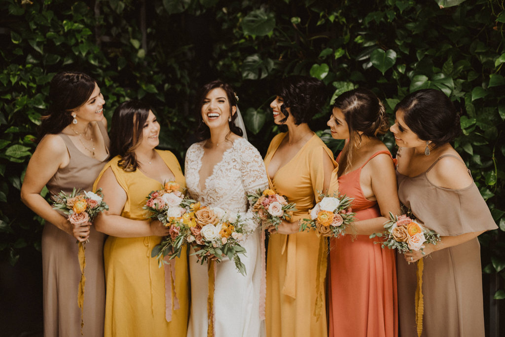 Modern Fall wedding bridal party with colorful bridesmaid dresses in golden yellow orange and taupe at The Wood Shed in Vista California