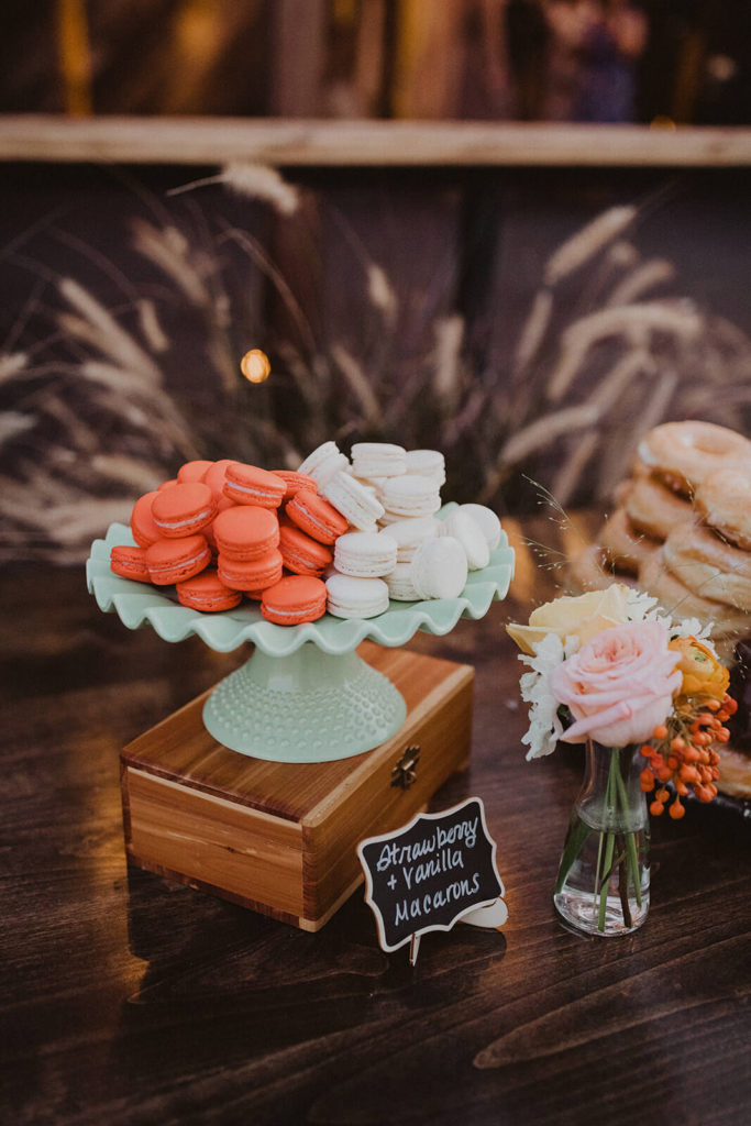 Fall wedding dessert table red and white macarons with colorful fall bud vase flowers at The Wood Shed in Vista California