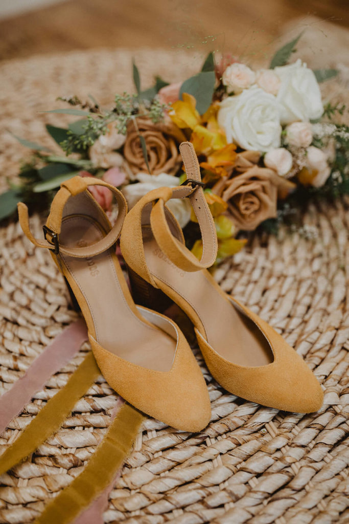 Golden suede wedding shoes with ankle straps and a colorful Fall bridal bouquet