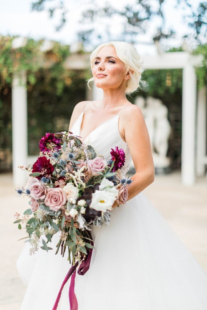 Winter wedding blonde bride holding a large bouquet with burgundy ribbon at Orcutt Ranch
