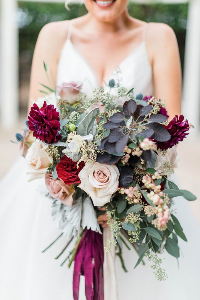 Organic blue and burgundy winter wedding bouquet with burgundy cream and white flowers at Orcutt Ranch