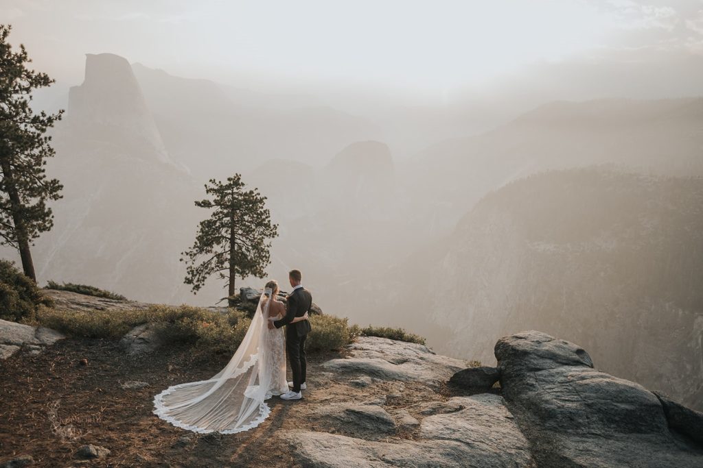 Bride and groom overlooking Yosemite and Half Dome during their elopement at Washburn Point