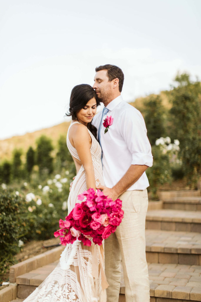 Outdoor pink bougainvillea wedding groom and bride with pink bouquet