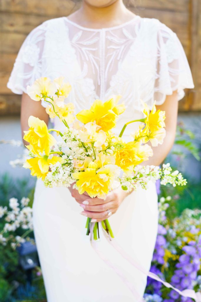 Bride holding a small bouquet with yellow daffodils