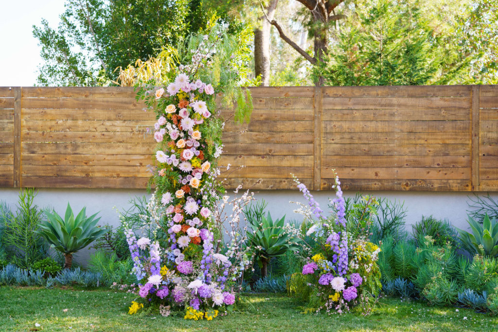 Colorful floral arch for backyard Bridgerton inspired wedding ceremony