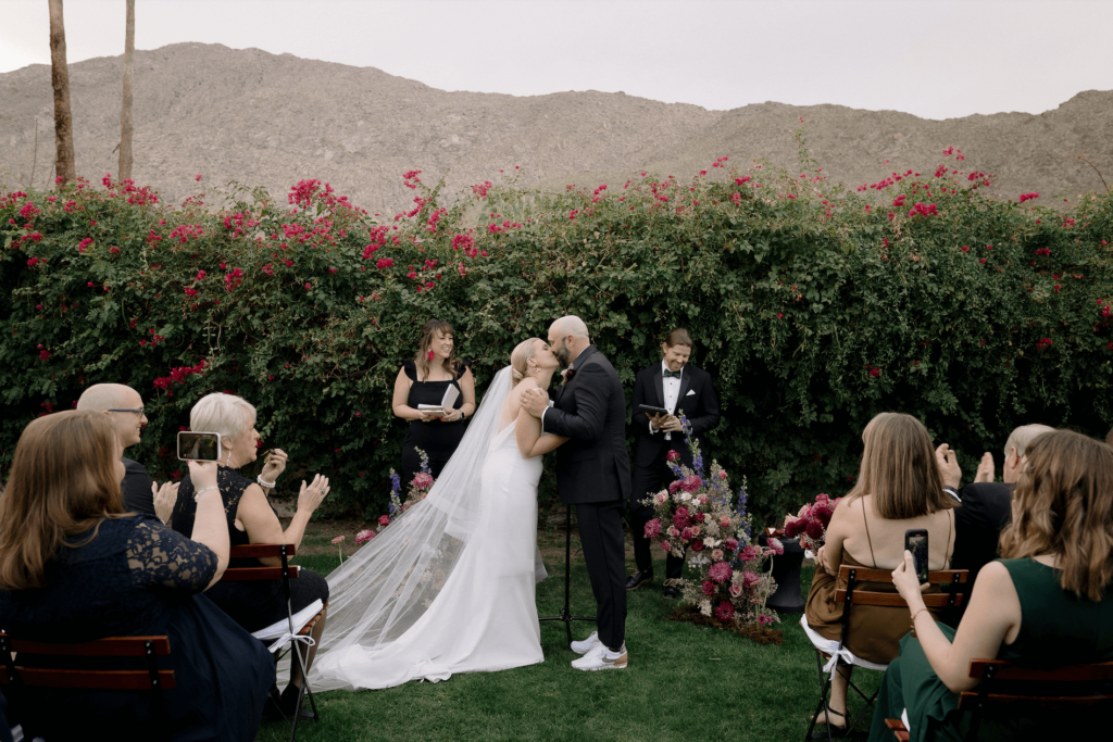 Couple's first kiss at outdoor Palm Springs wedding ceremony at Casa Cody