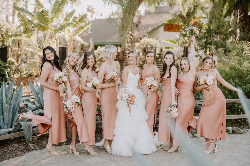 Bridesmaids wearing peach silk dresses with bride