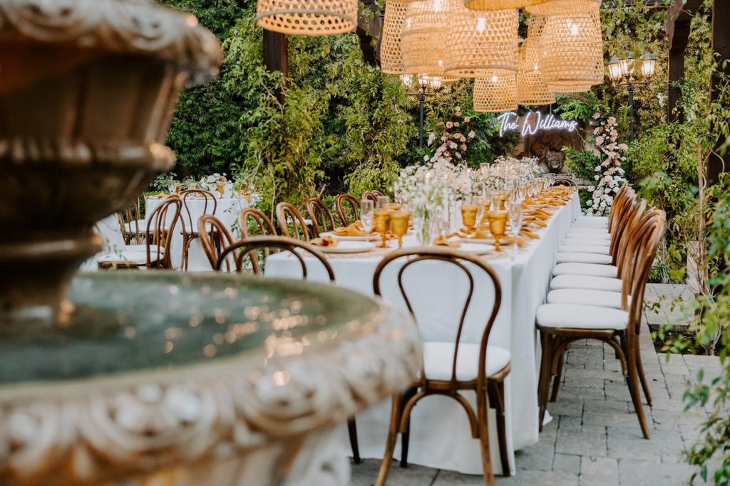Long wedding reception table with boho lanterns and fountain