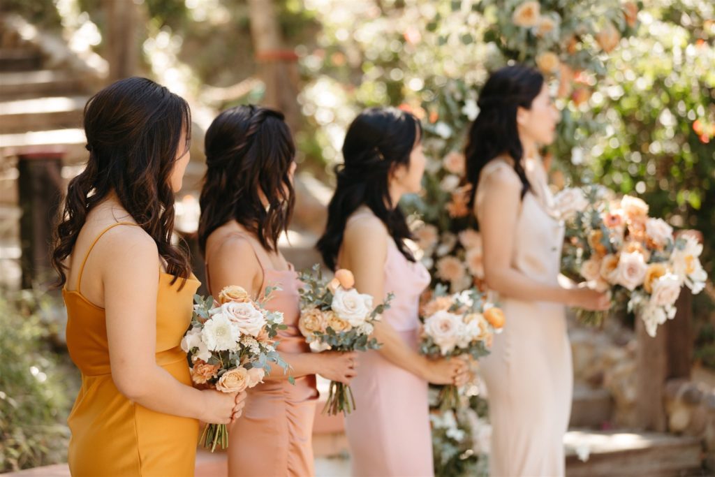 Bridesmaids holding bouquets at Rancho Las Lomas wedding ceremony