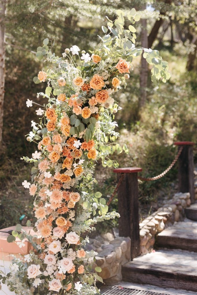 Floral wedding arch with peach and cream color flowers