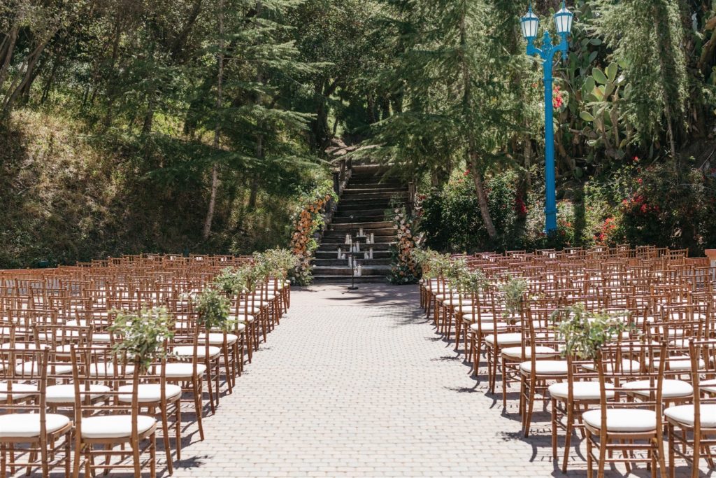 Outdoor wedding ceremony with floral arch at Rancho Las Lomas venue