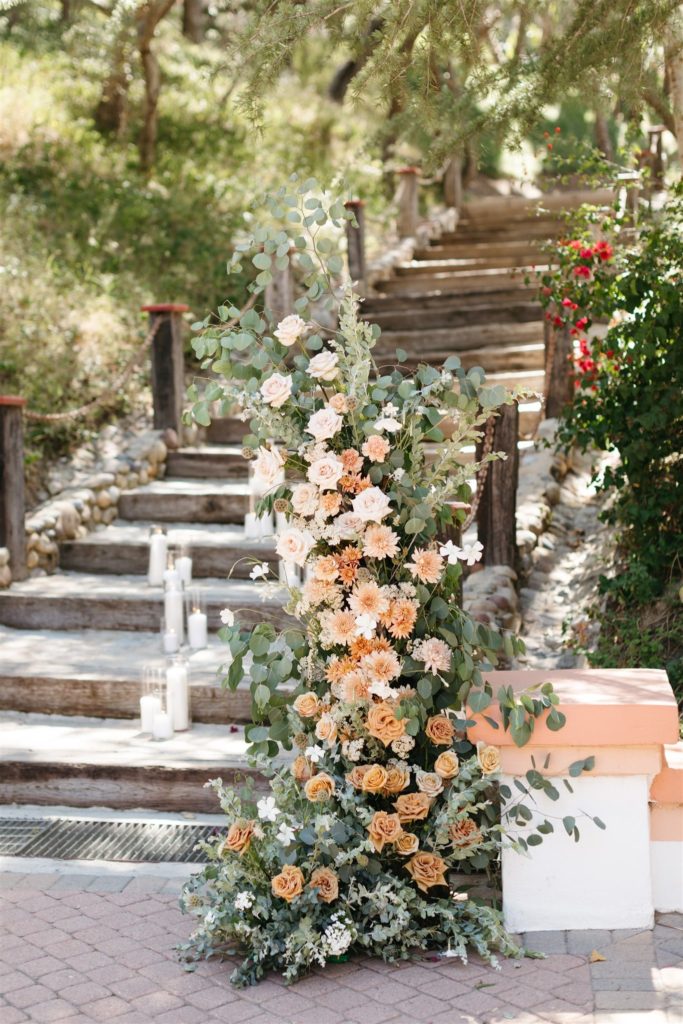 Fresh floral arch at outdoor wedding ceremony