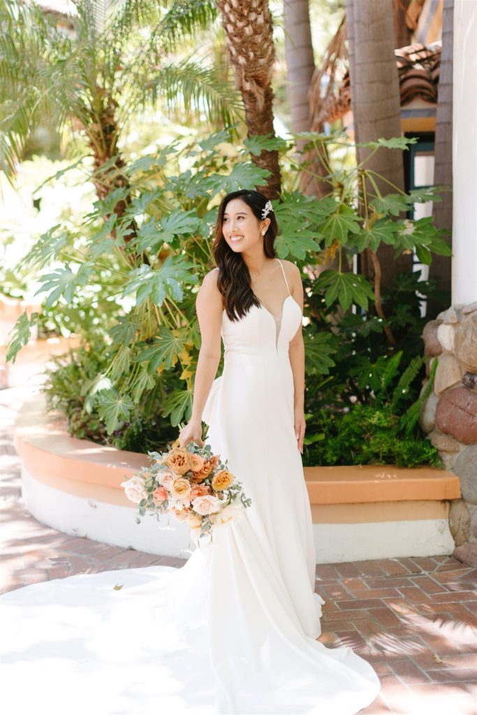 Modern bride carrying peach and cream bouquet