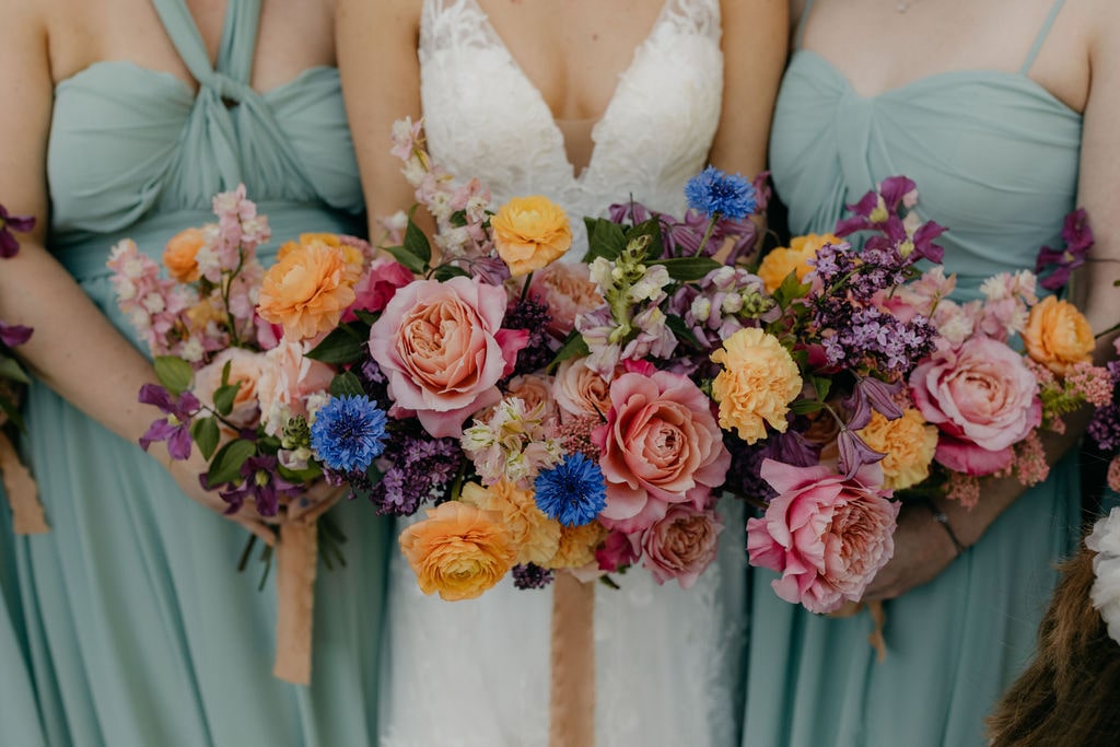 Bride and bridesmaids holding colorful wedding bouquets