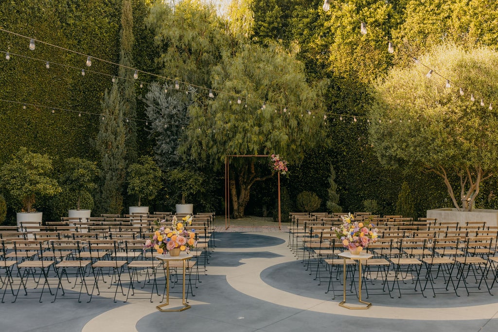 Outdoor wedding ceremony with colorful florals and fresh greenery at The Fig House venue