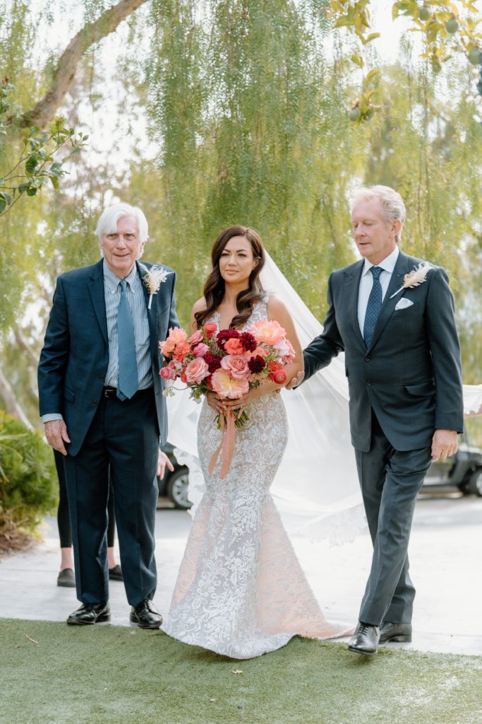 Bride walking with fathers down the aisle at Malibu wedding