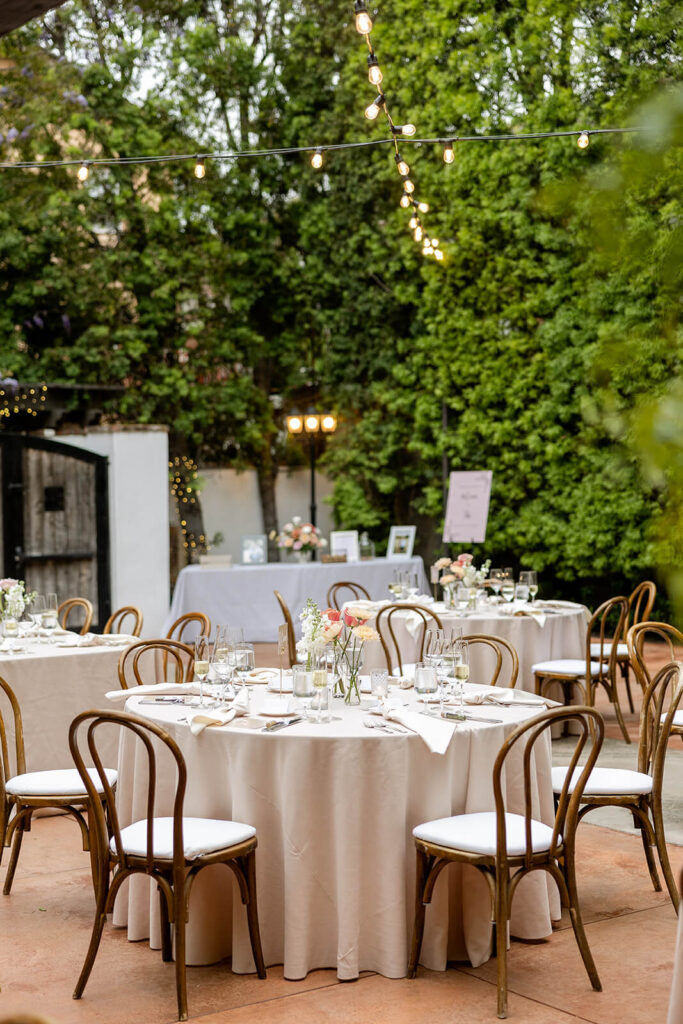 Round wedding reception tables with taupe linen and bud vase centerpieces at Franciscan Gardens