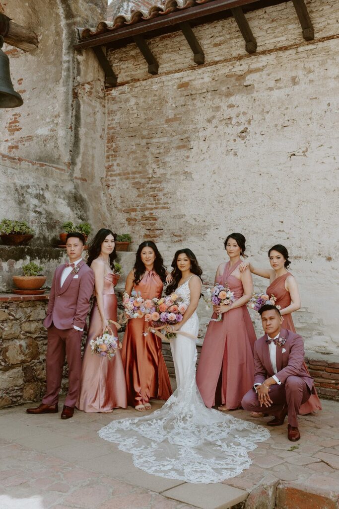 Wedding party standing with bride in a lace gown