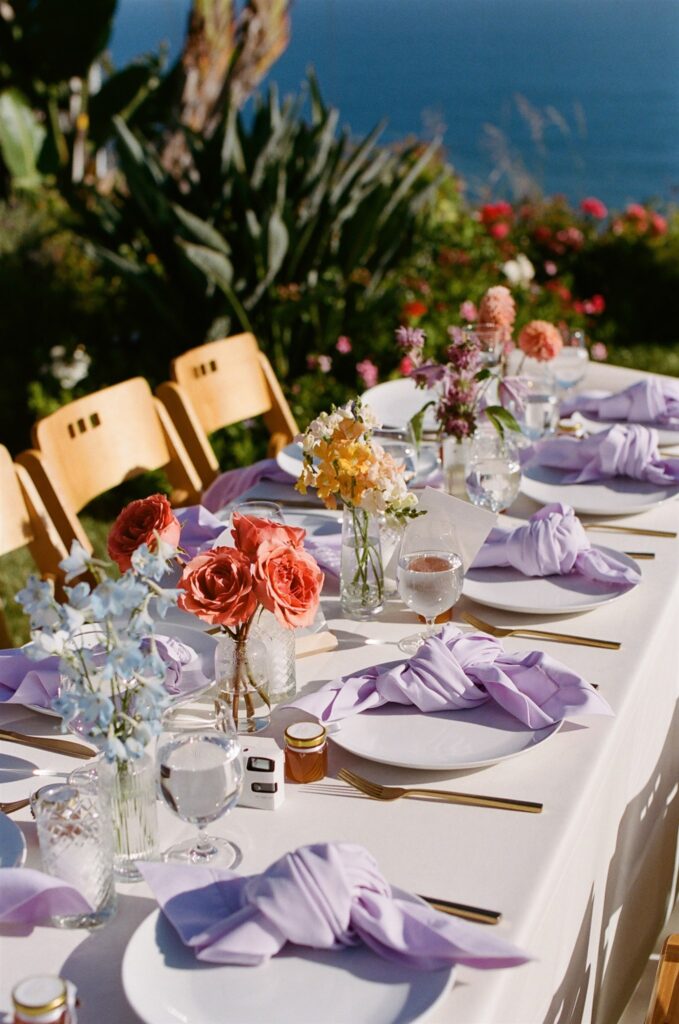 colorful tablescape with lilac napkins and colorful bud vases